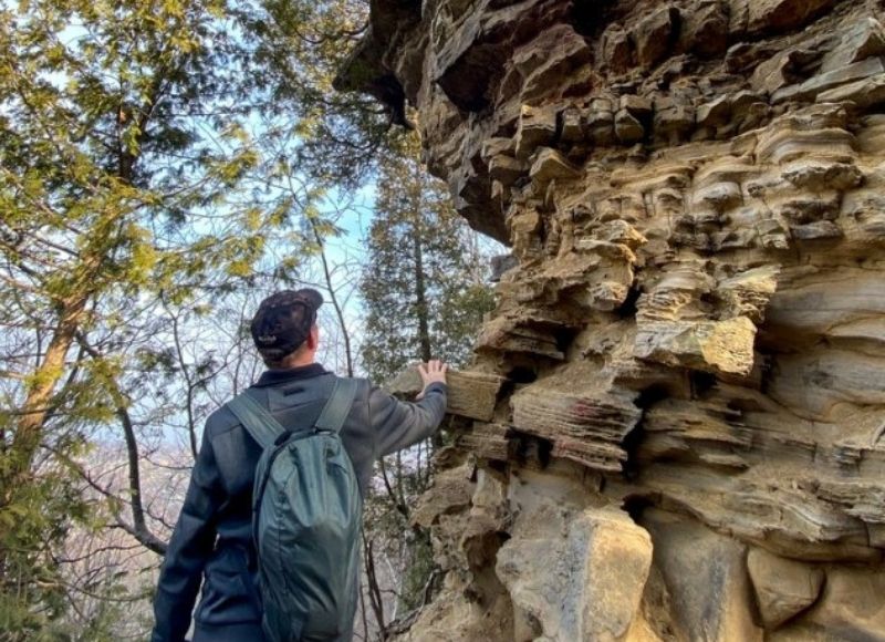 Person touching rock outcropping